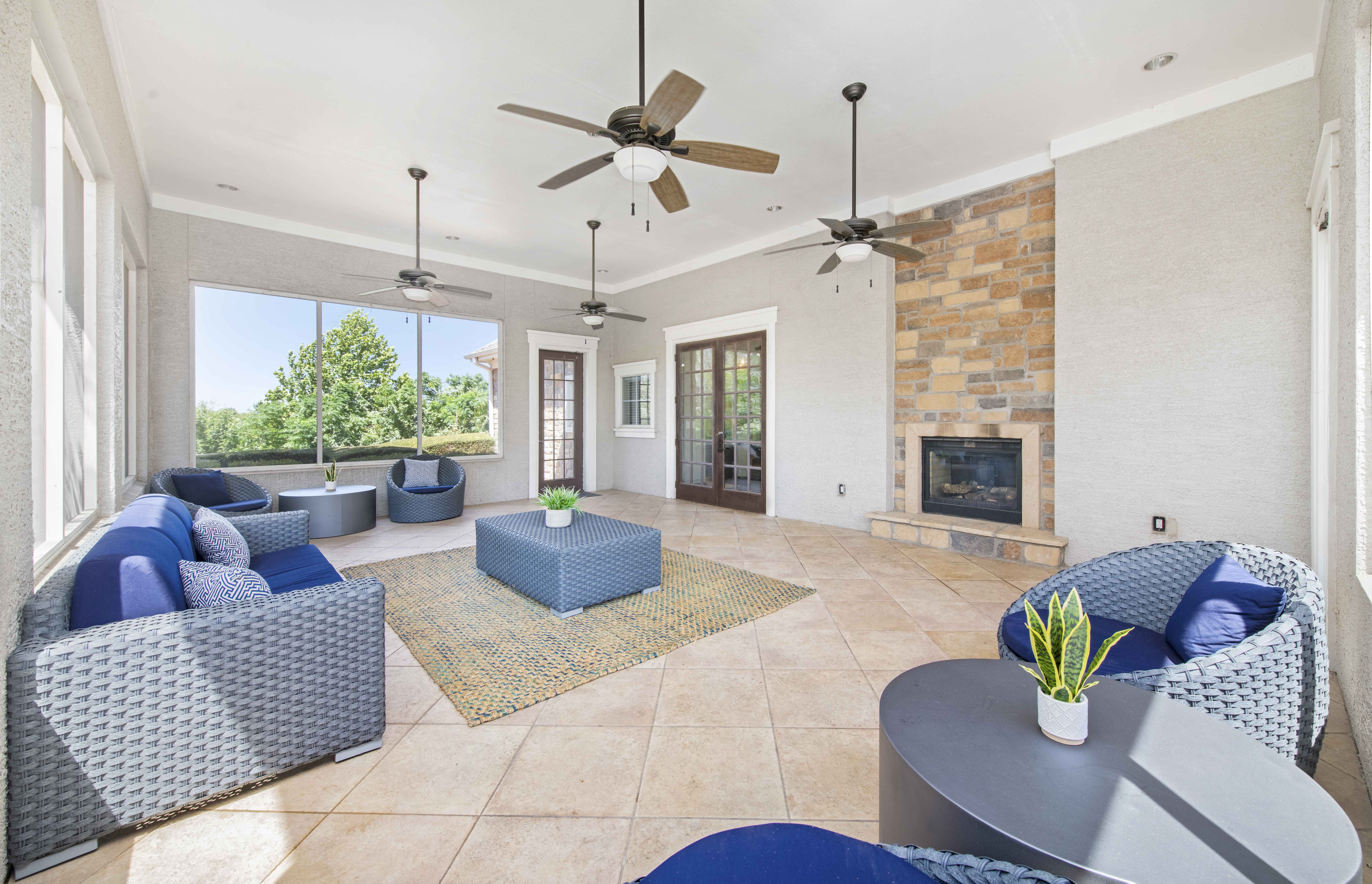the living room has a stone fireplace and blue furniture